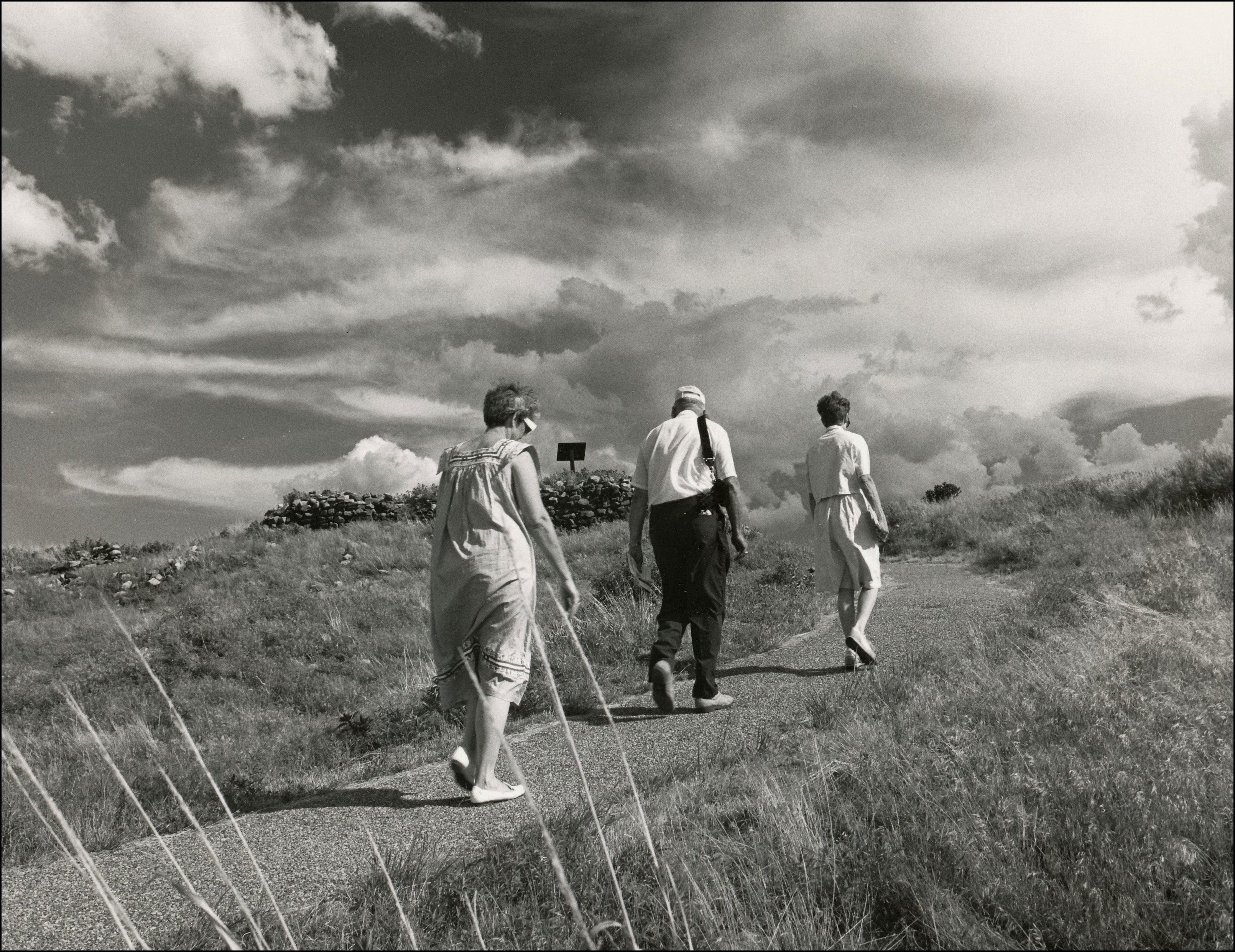 Three people walking up a trail at an Historical Park