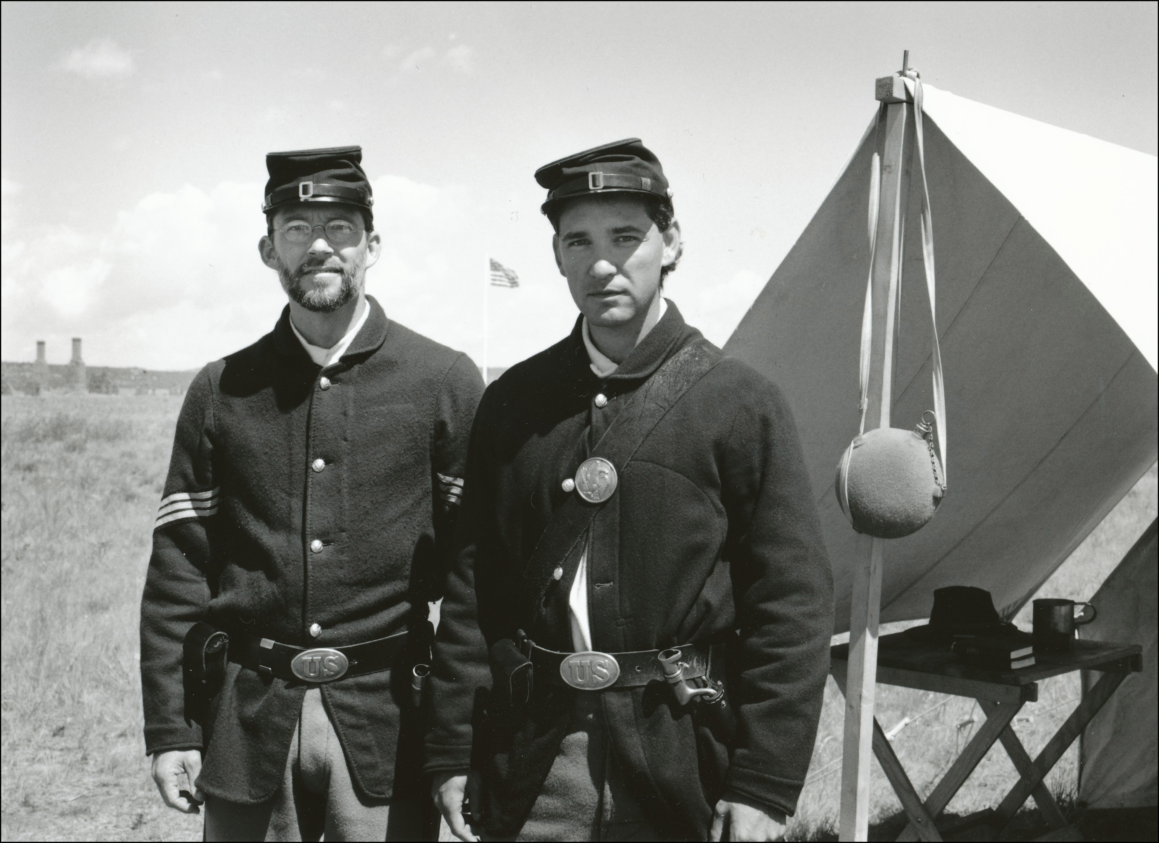 Two men dressed up as soldiers in front of old tent at an old fort