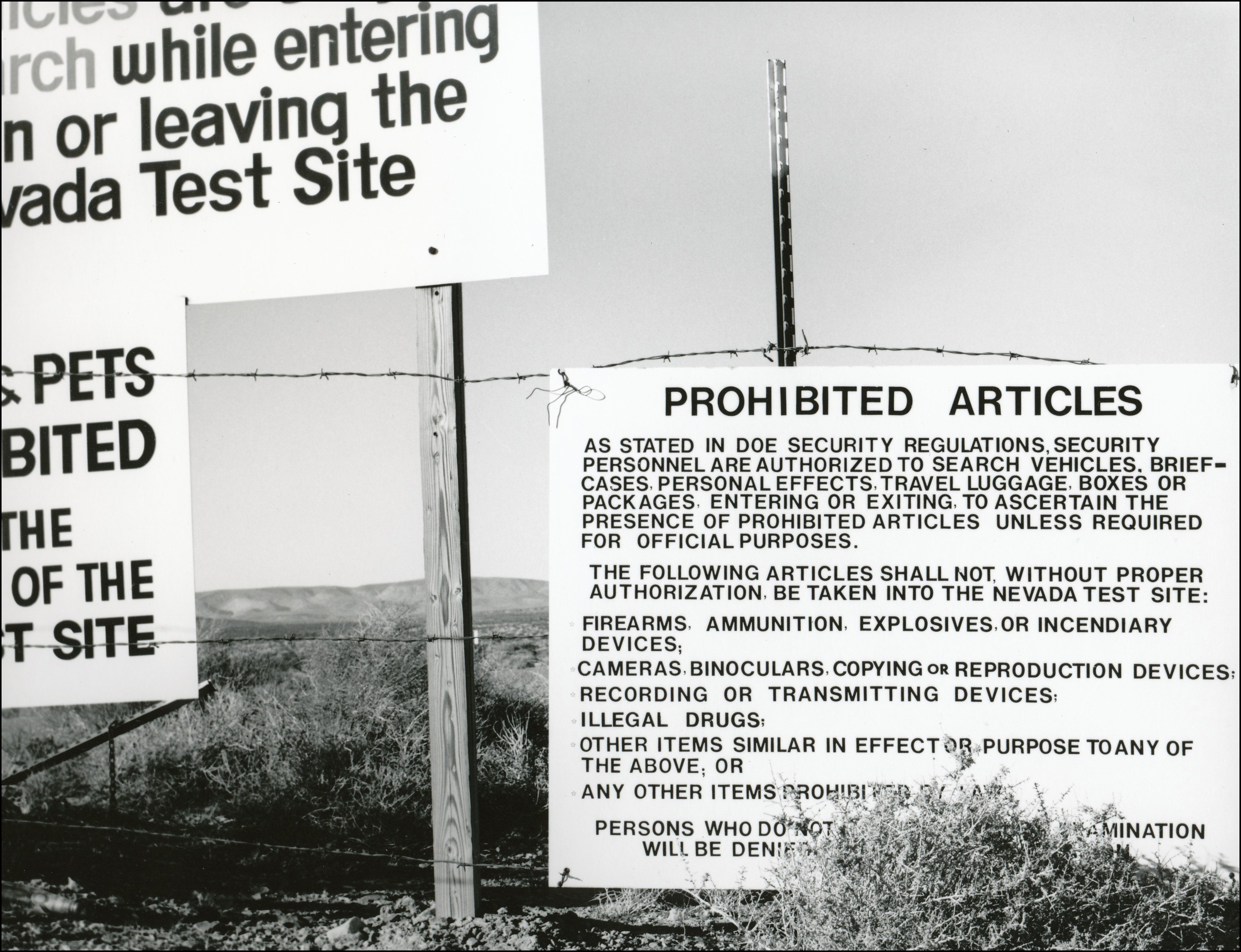 Warning signs for nuclear proving grounds hanging on fence