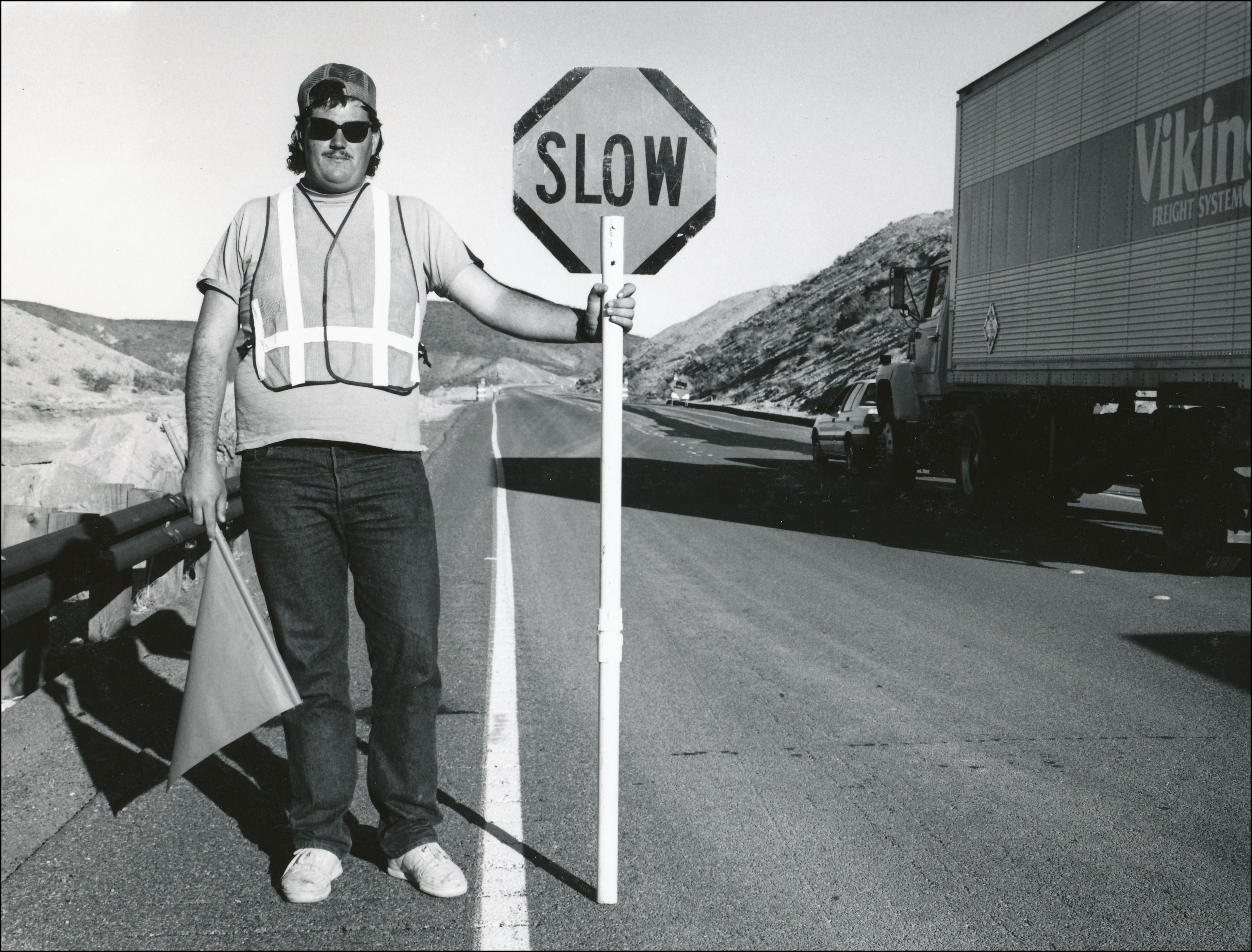 Highway construction worked holding a slow sign