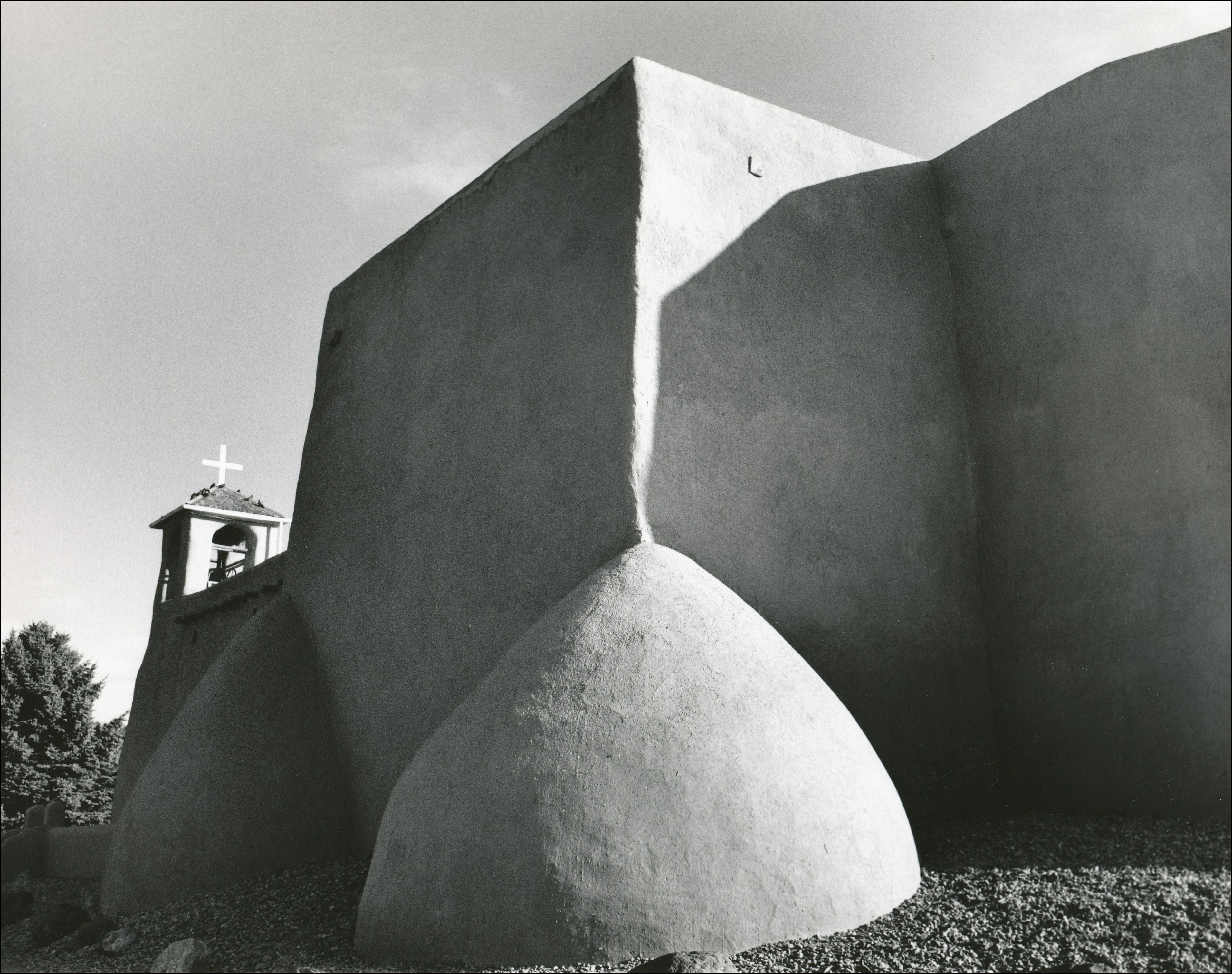 Back view of an adobe church with shadows from afternoon sunlight