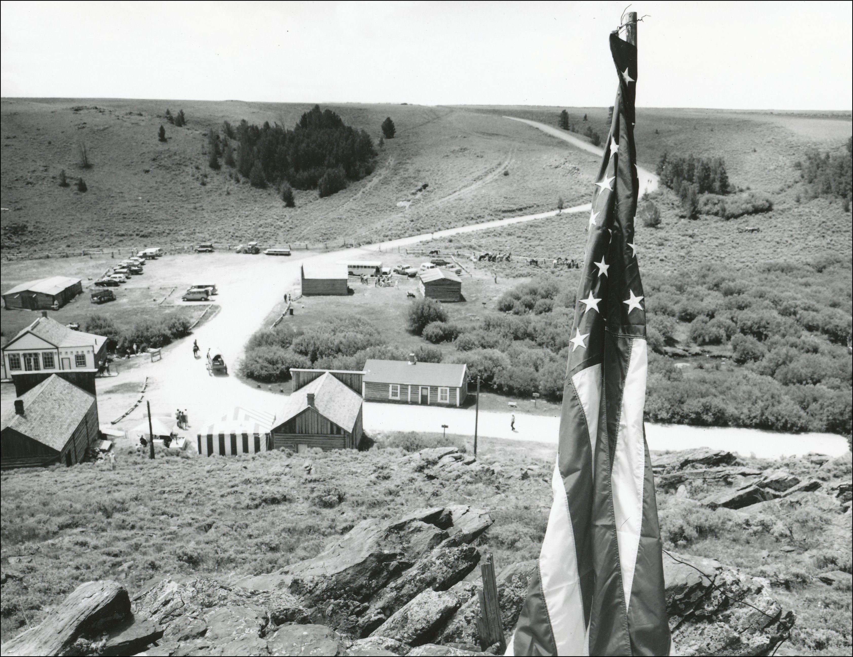 Looking down on a small town from a hill with an American flag on the right hand side